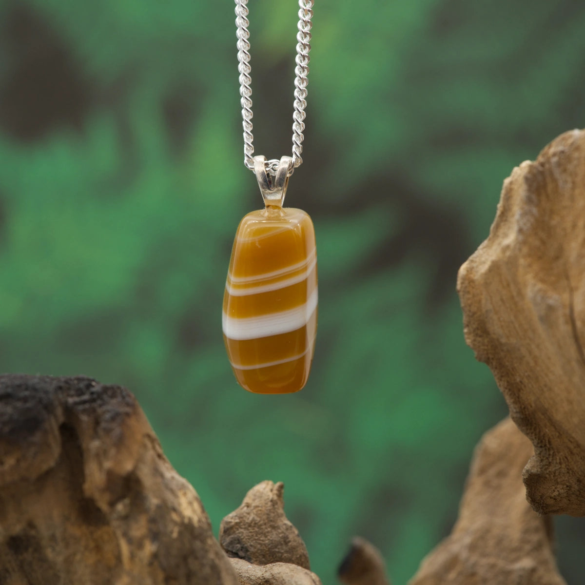 Gebänderter Achat-Anhänger in harmonischen Farben – symbolisiert Stabilität und Struktur.